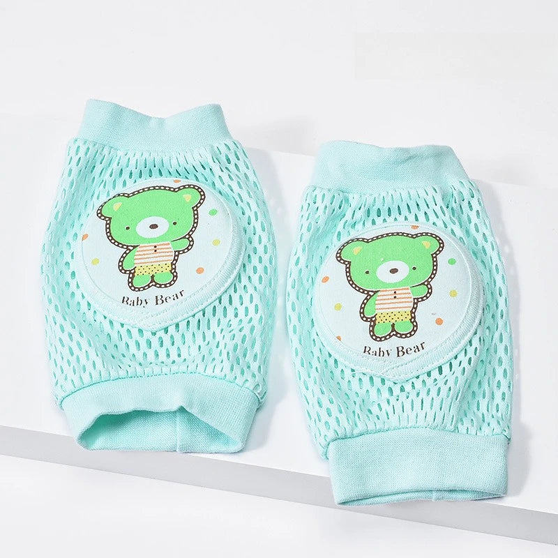 Pair of light green baby knee pads with a green bear design on a white background